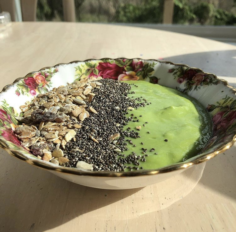 Green smoothie bowl topped with fresh fruit