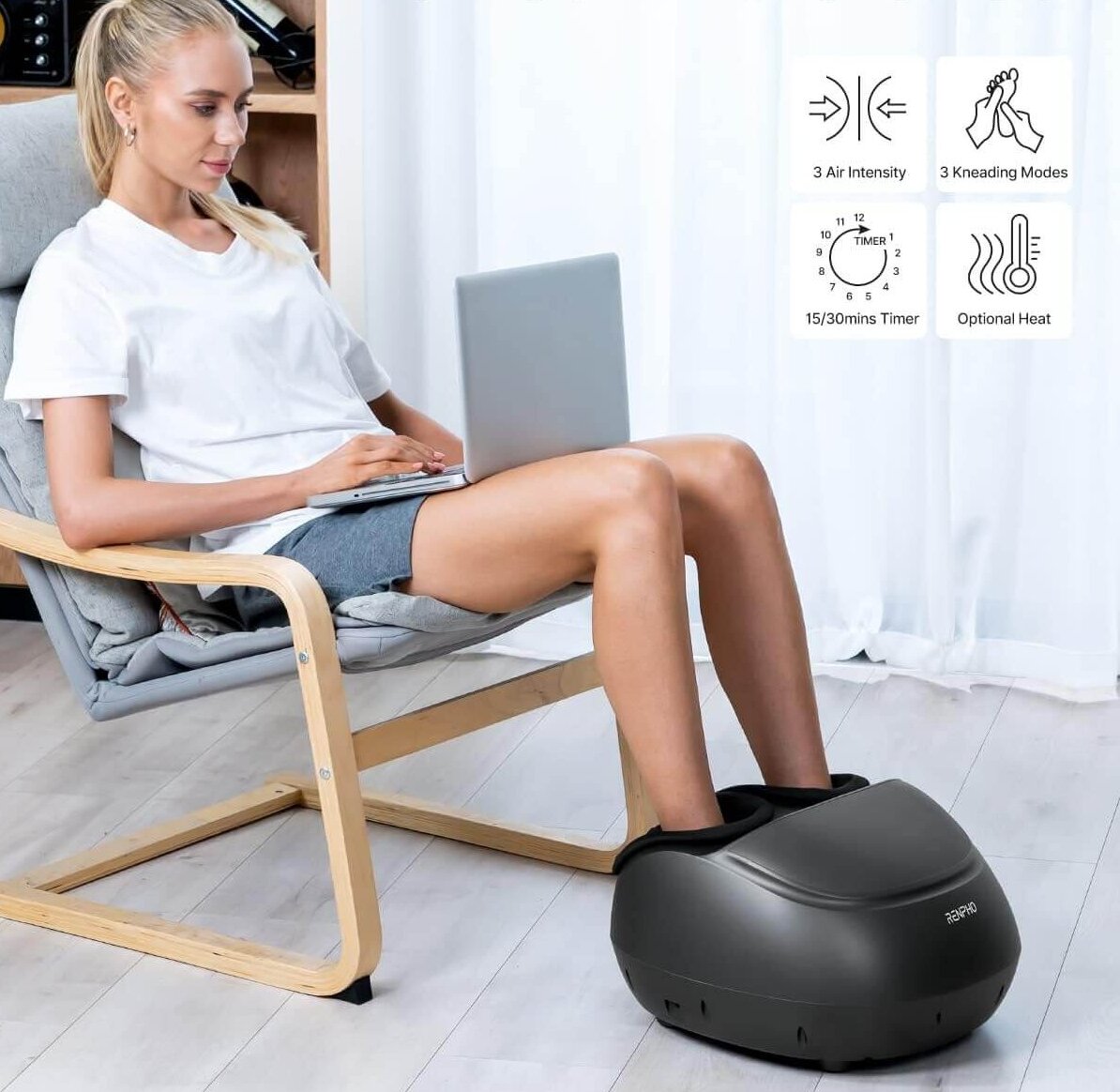 Woman using foot massager while sitting in a chair using her laptop