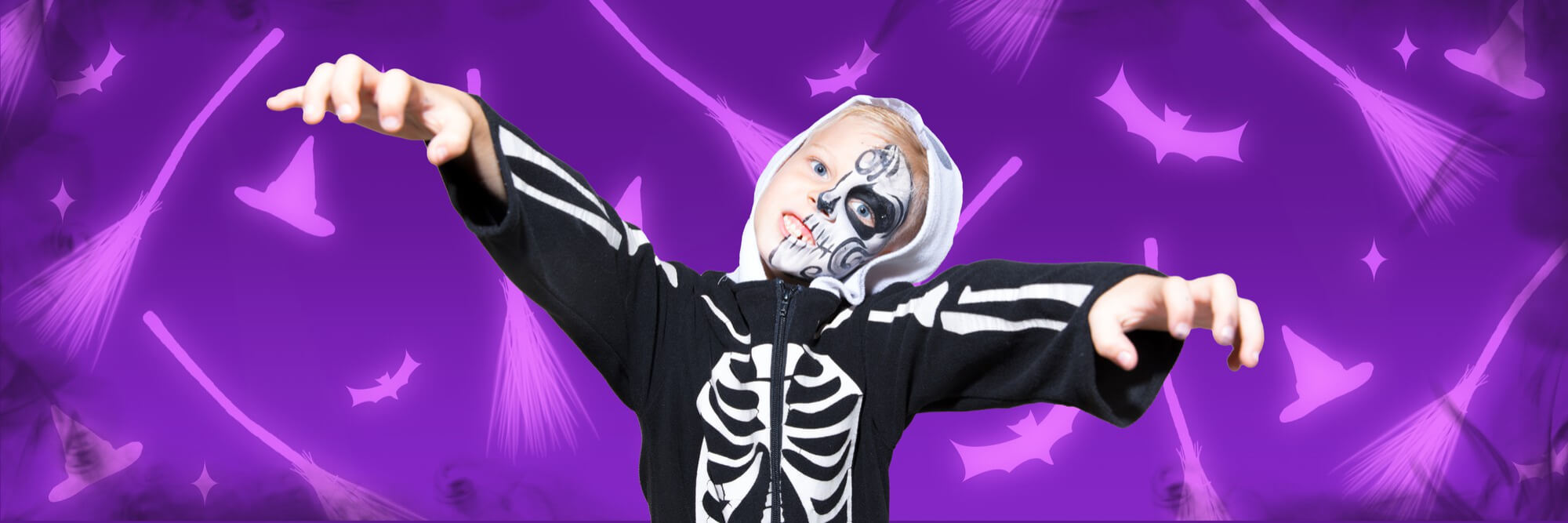 boy dressed as vampire for Halloween on scary purple background