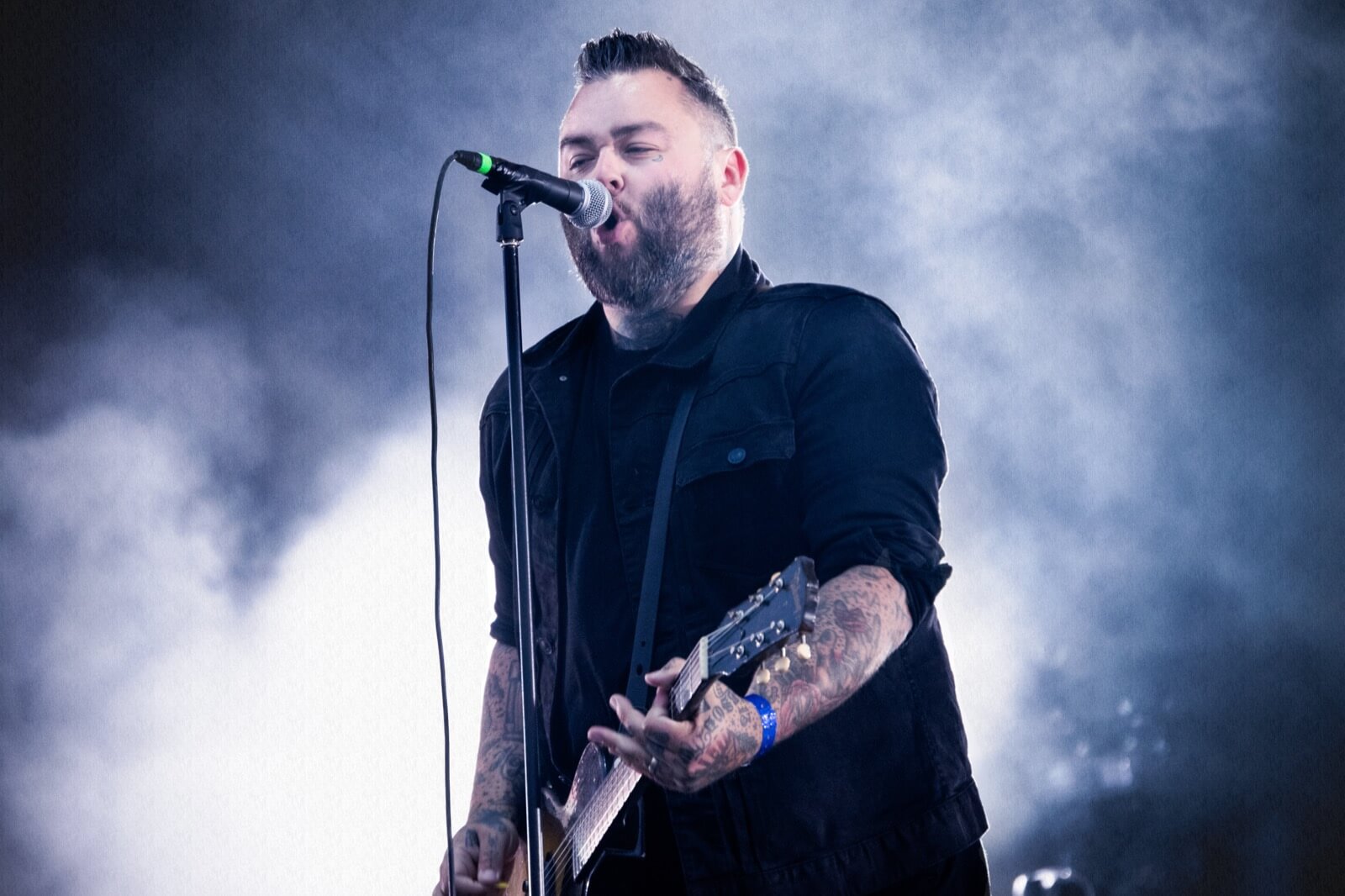 Alexisonfire vocalist singing on a smoke-filled stage