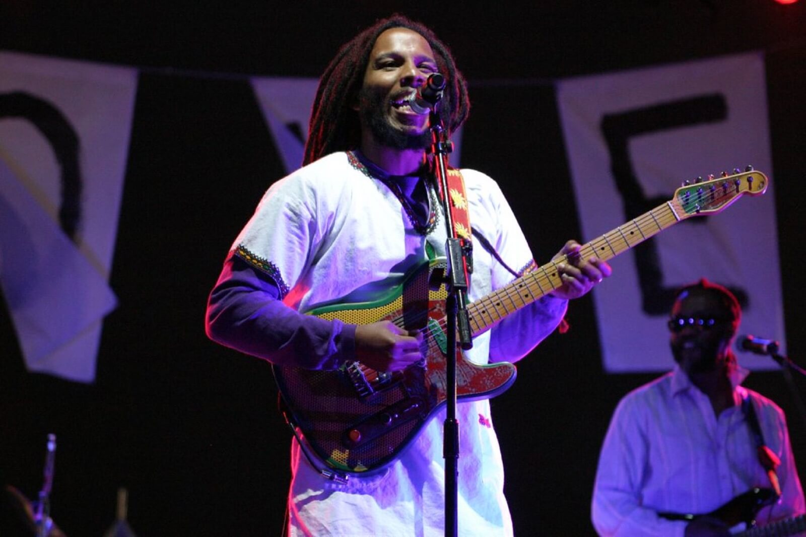 Ziggy Marley singing and playing guitar during a live concert