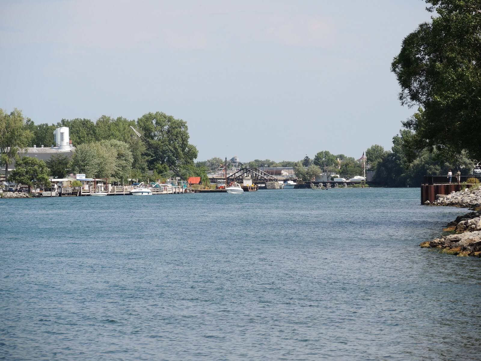 The view from Niawanda Park looking across the water toward the mouth of Tonawanda Creek, with marina docks and low buildings along the far shore